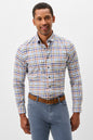A man wearing a long-sleeve button-down shirt with a multicolor plaid pattern in blue, orange, and white, paired with blue jeans and a brown belt, against a light gray studio background.