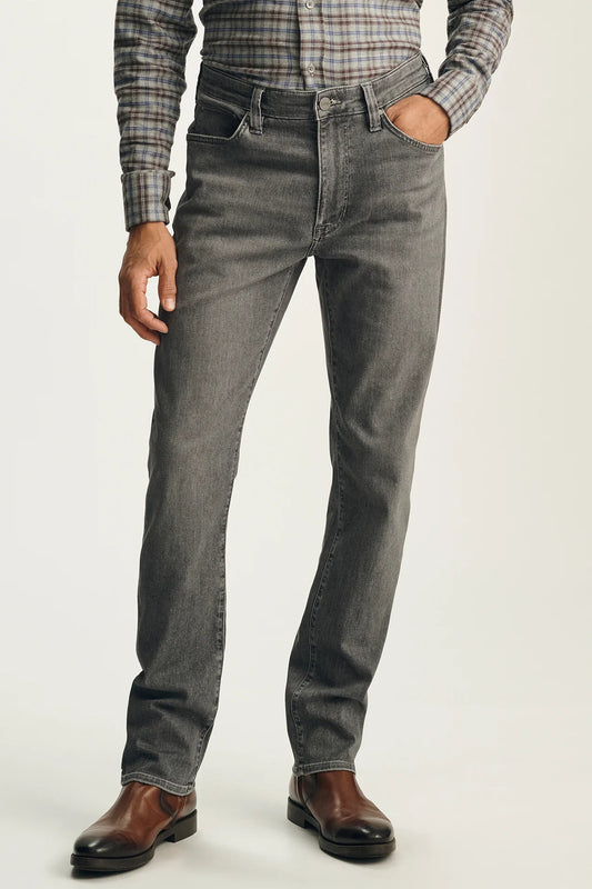 A person wearing slim-fit gray denim jeans with a plaid button-down shirt and brown leather shoes, shown from the waist down against a plain light background.