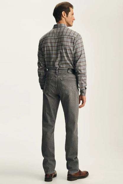 A man shown from the back wearing a gray plaid button-down shirt tucked into gray jeans with a black belt, paired with brown leather shoes, against a light gray studio background.