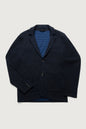 A dark navy blue wool-blend blazer jacket with notch lapels and two front buttons, styled open over a blue and navy striped knit sweater, laid flat against a light gray background.