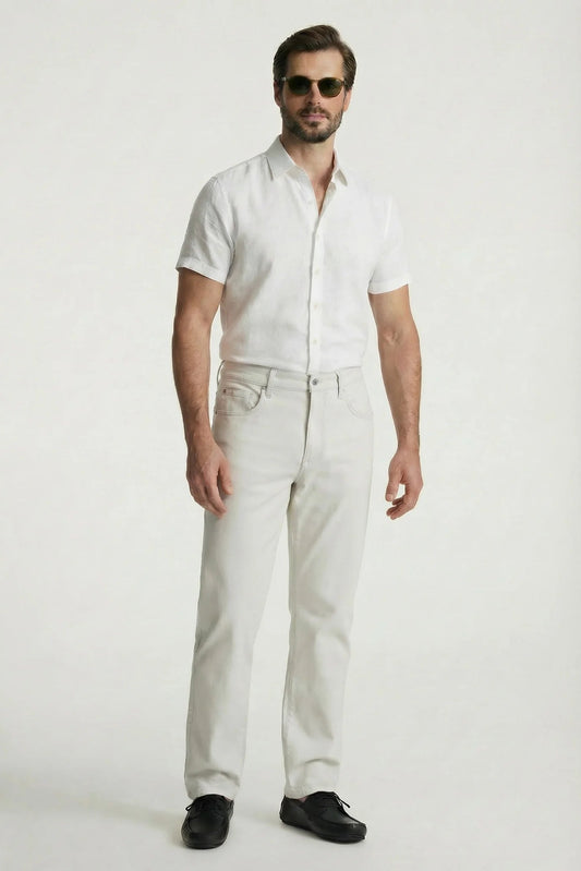 Man wearing a white shirt and light-colored pants on a white background
