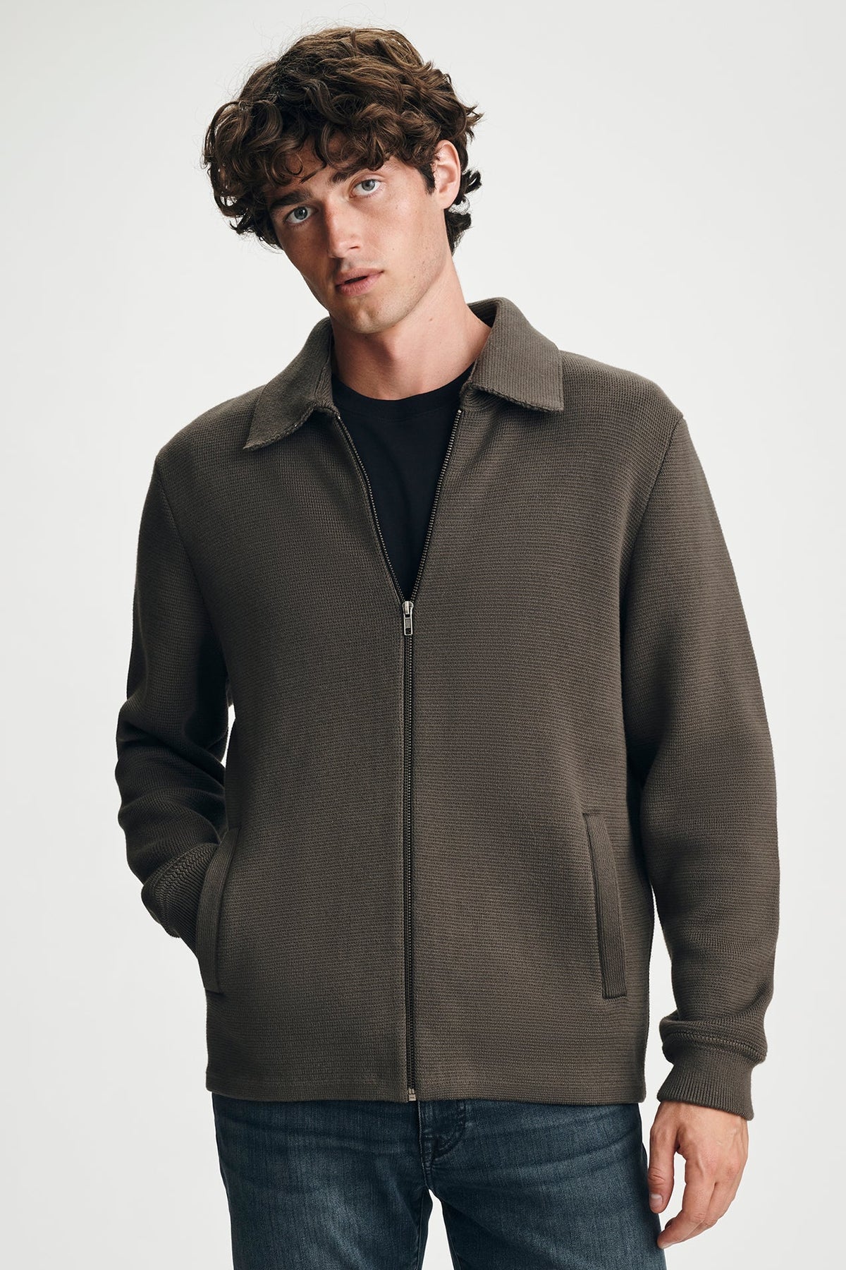 man wearing brown sweater with jeans