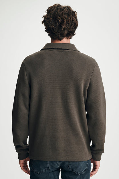 back view of man in brown sweater in jeans