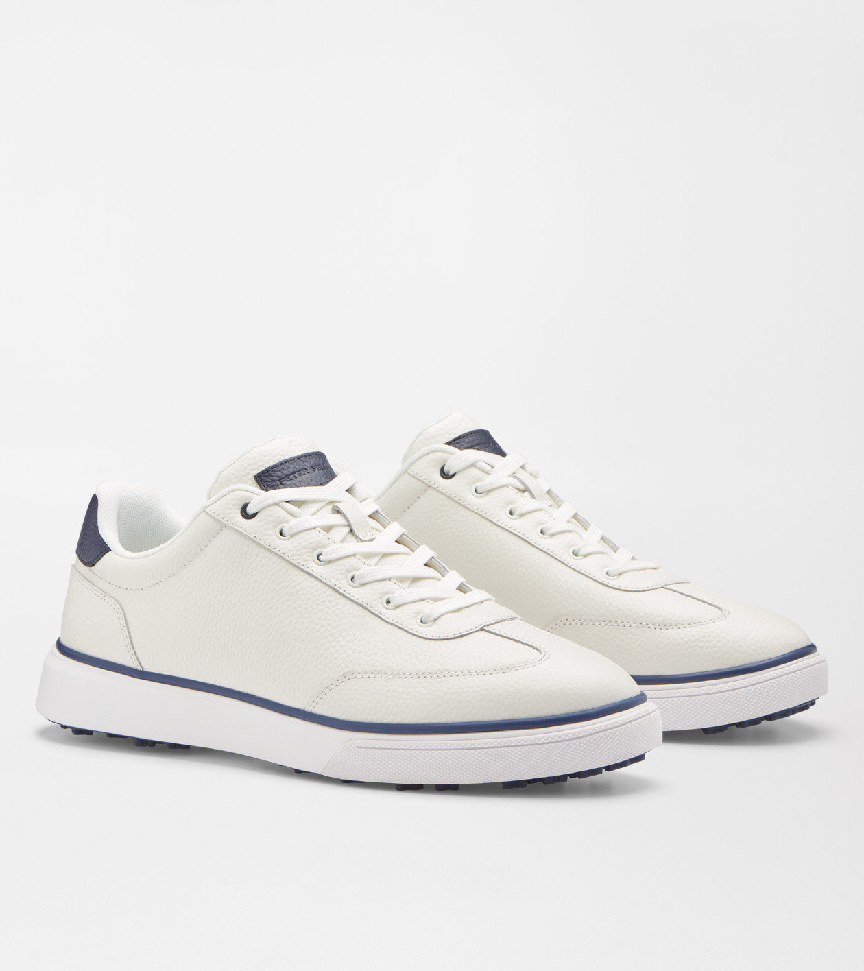 A pair of white leather low-top sneakers with navy blue accents on the heel tab, laces, and midsole stripe, shown on a light gray studio background.