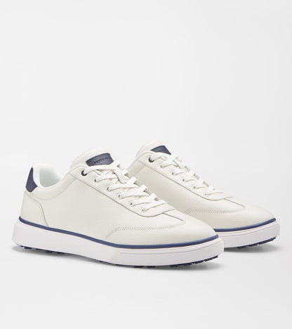 A pair of white leather low-top sneakers with navy blue accents on the heel tab, laces, and midsole stripe, shown on a light gray studio background.