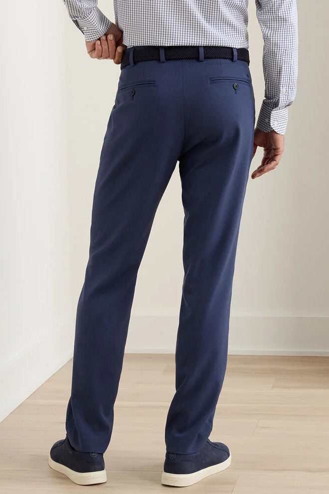Person wearing navy blue dress pants with a plain background
