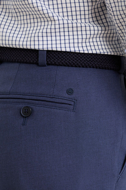 Navy pants with a checkered shirt on a neutral background