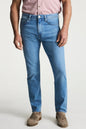 Person wearing blue jeans and a pink shirt on a white background