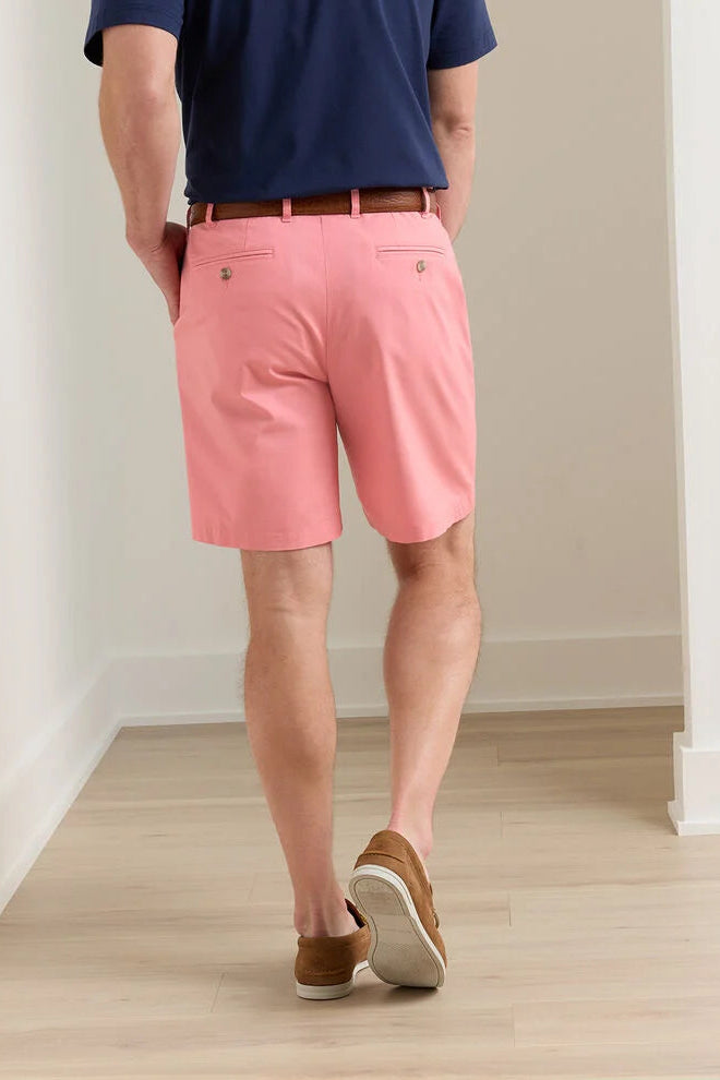 Person wearing pink shorts and a navy shirt in a minimal indoor setting