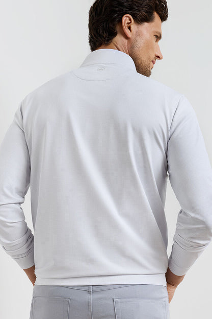 Man wearing a light gray long-sleeve shirt against a plain background