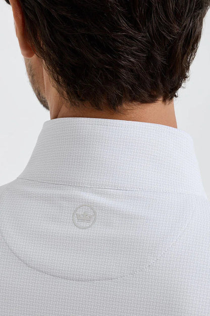 Close-up of a person wearing a light gray checkered shirt with a brand logo on a white background