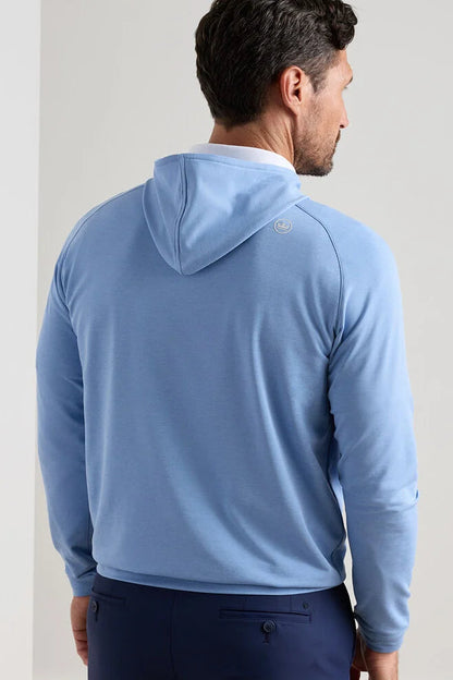 Man wearing a light blue hoodie with a brand logo on the back against a plain background