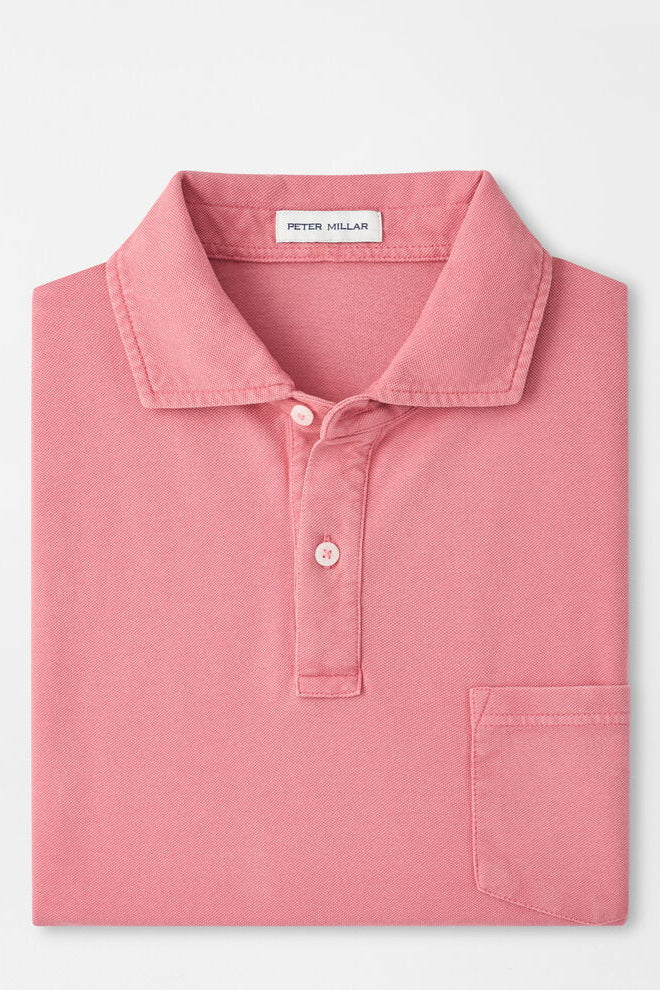 Pink polo shirt with 'Peter Millar' label on a light gray background