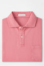 Pink polo shirt with 'Peter Millar' label on a light gray background