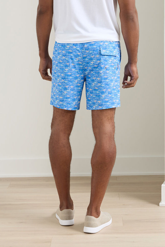 Person wearing blue patterned shorts on a plain background