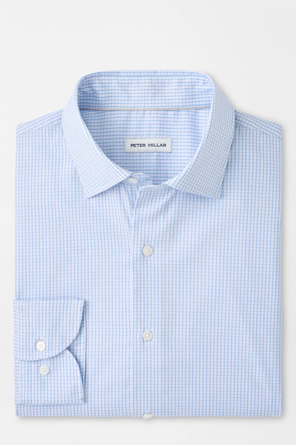 Folded light blue checkered shirt with 'Peter Millar' label on a white background