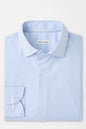 Folded light blue checkered shirt with 'Peter Millar' label on a white background