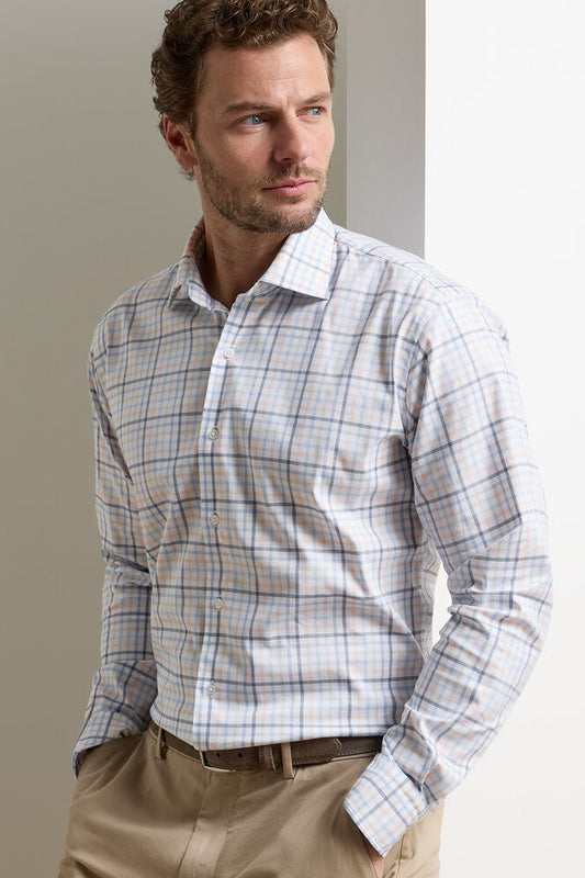 Man wearing a plaid shirt and beige pants against a neutral background