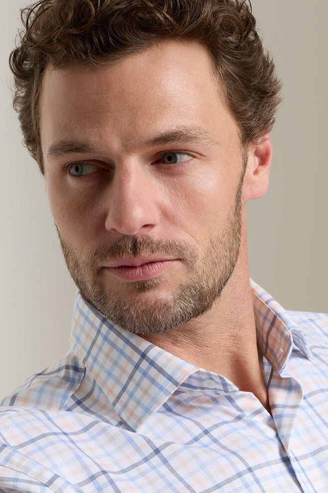 Man wearing a plaid shirt against a neutral background