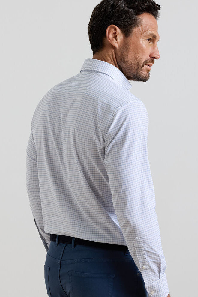 Man wearing a light blue checkered shirt against a plain background