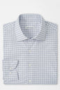 Folded checkered shirt with 'Peter Millar' label on a light gray background