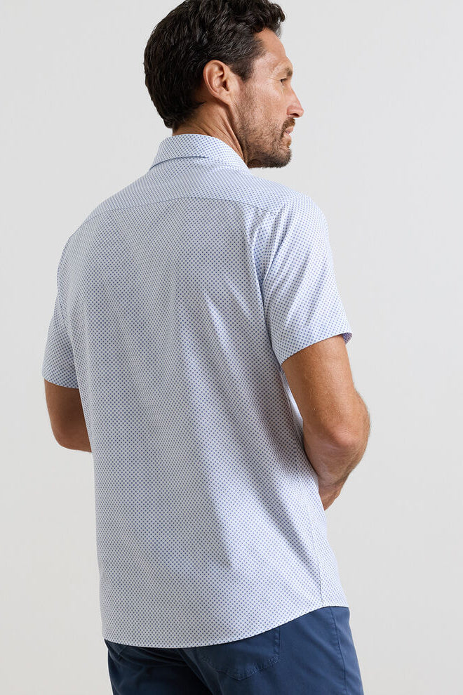 Man wearing a light blue patterned polo shirt against a plain background
