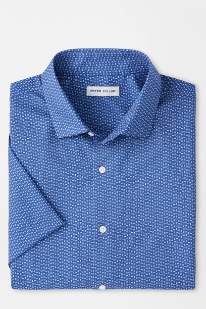 Folded blue patterned shirt with 'Peter Millar' label on a light gray background