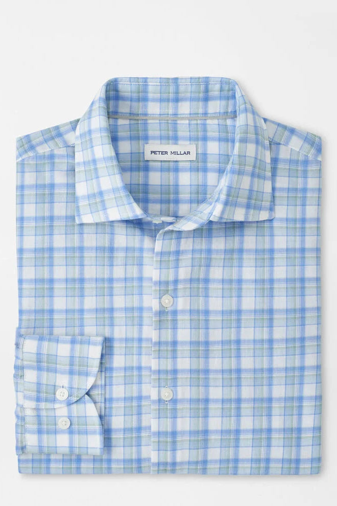 Folded blue and white checkered shirt with 'Peter Millar' label on a light gray background