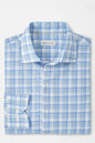 Folded blue and white checkered shirt with 'Peter Millar' label on a light gray background