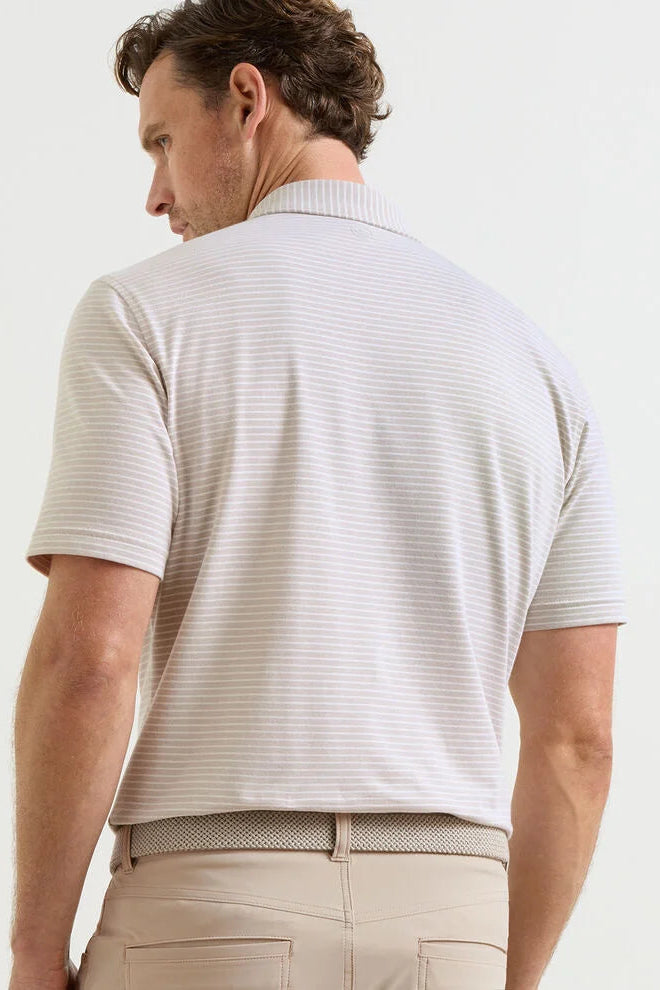 Man wearing a light-colored striped polo shirt and beige pants on a white background