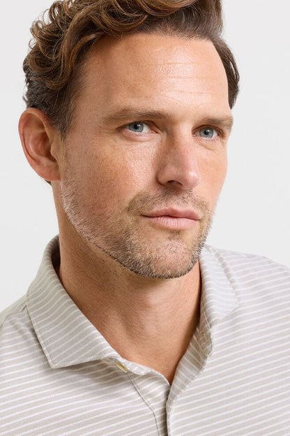 Man wearing a light-colored shirt against a plain background