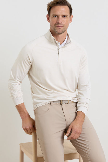 Man wearing a white long-sleeve shirt and beige pants on a light background