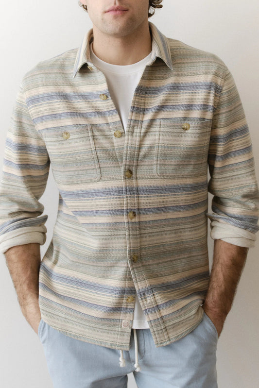 Man wearing a striped shirt with a neutral background