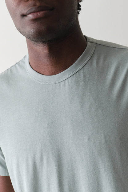 Man wearing a light gray t-shirt against a plain background