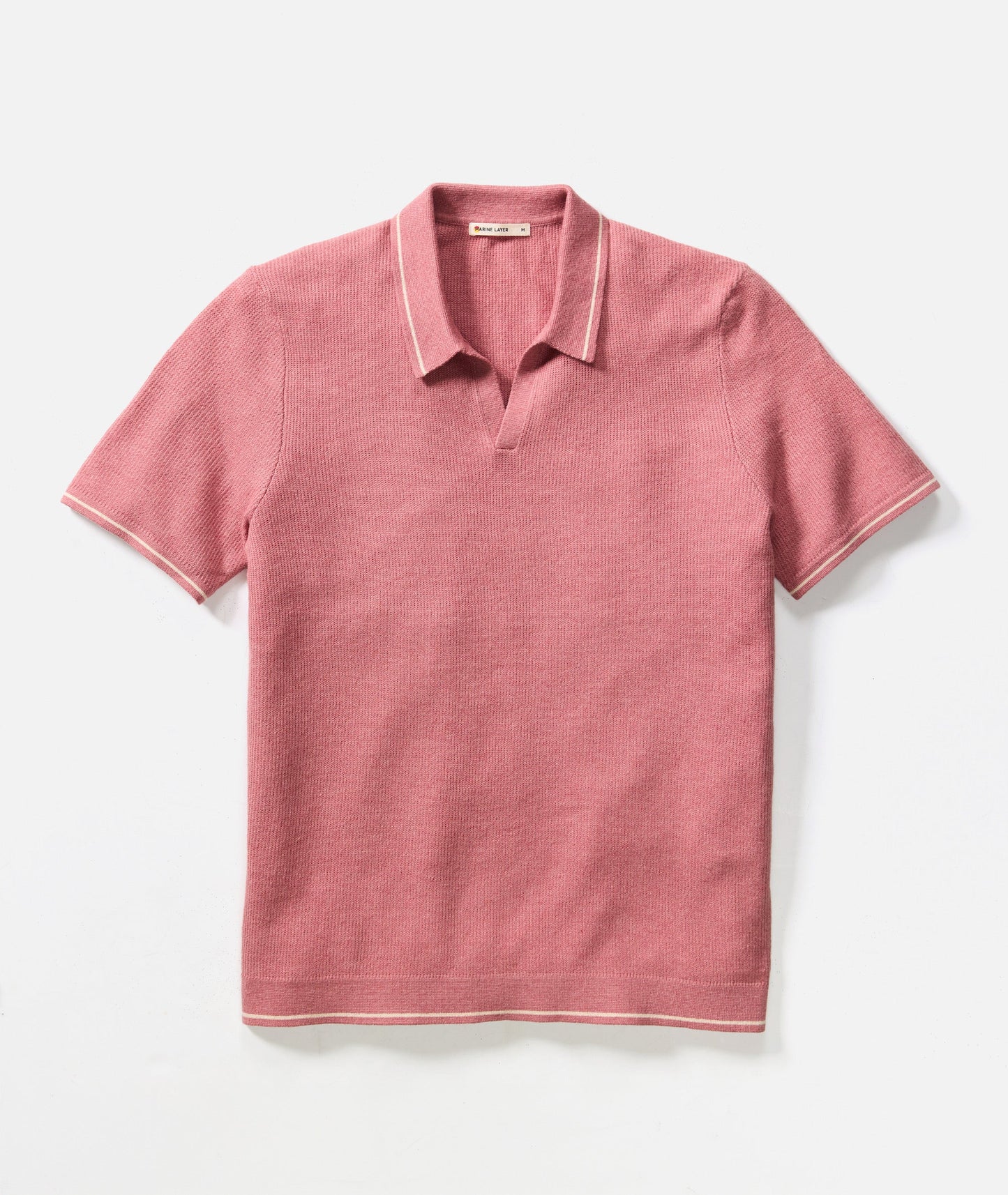 Pink polo shirt with white trim on a light gray background