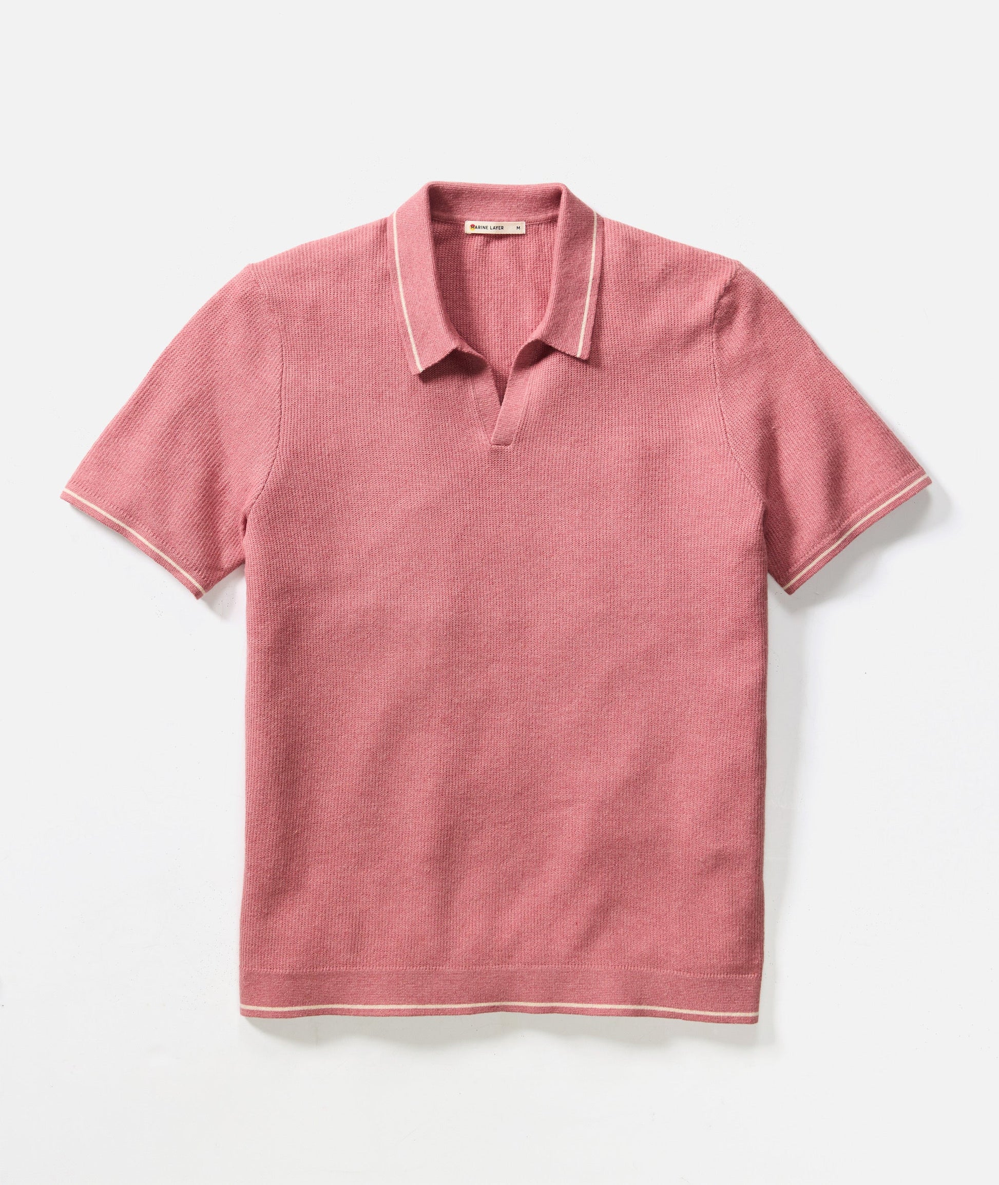 Pink polo shirt with white trim on a light gray background