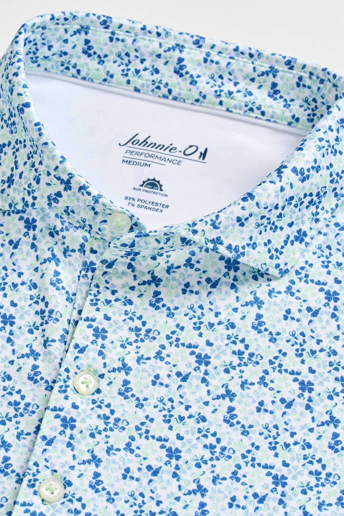 Close-up of a blue and white floral patterned shirt with 'Johnnie-O' branding.
