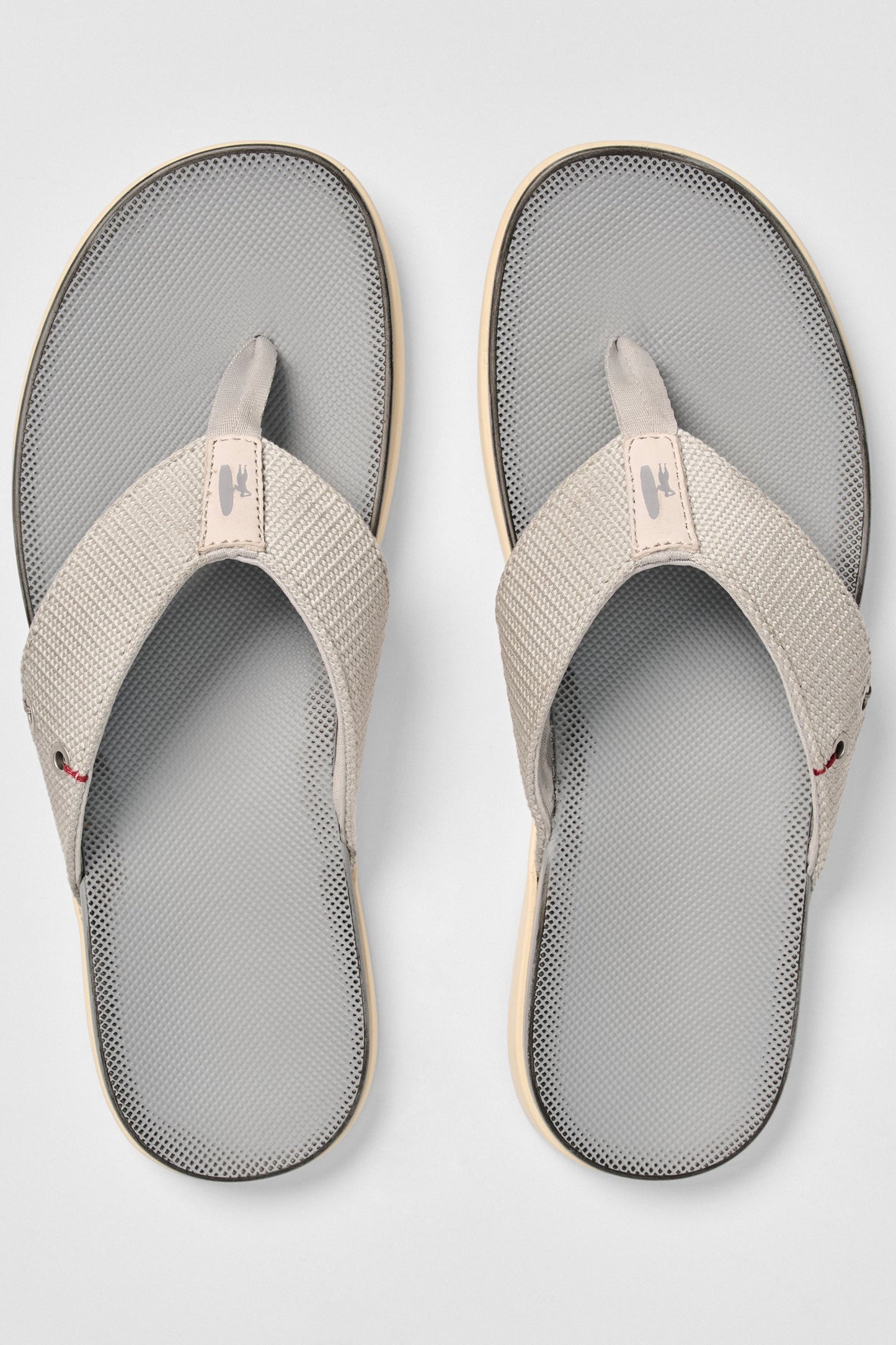 Pair of gray and beige sandals on a light gray background
