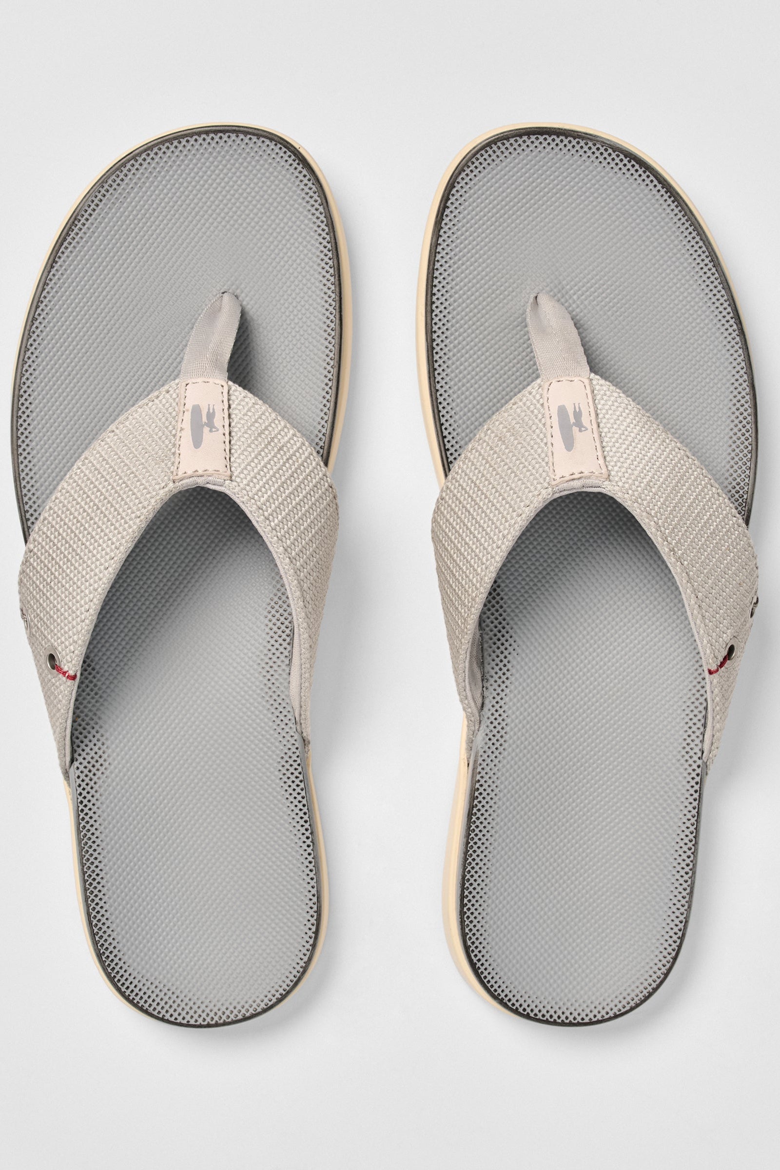 Pair of gray and beige sandals on a light gray background