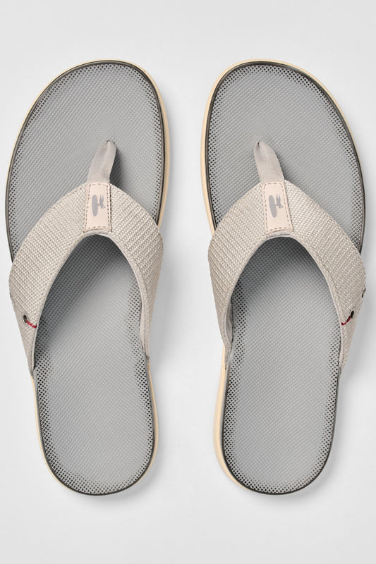 Pair of gray and beige sandals on a light gray background