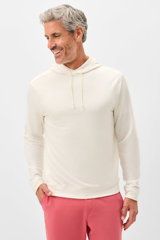 Man wearing a cream hoodie and pink pants on a white background