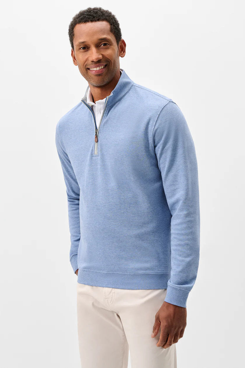 Man wearing a light blue quarter-zip sweater on a white background