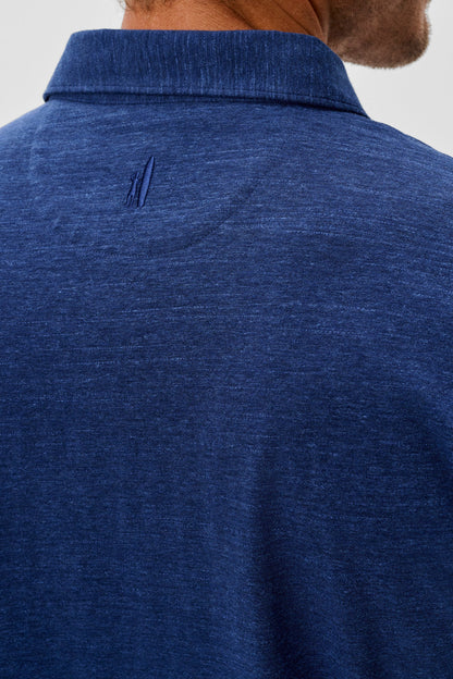Close-up of a blue polo shirt with a collar against a neutral background