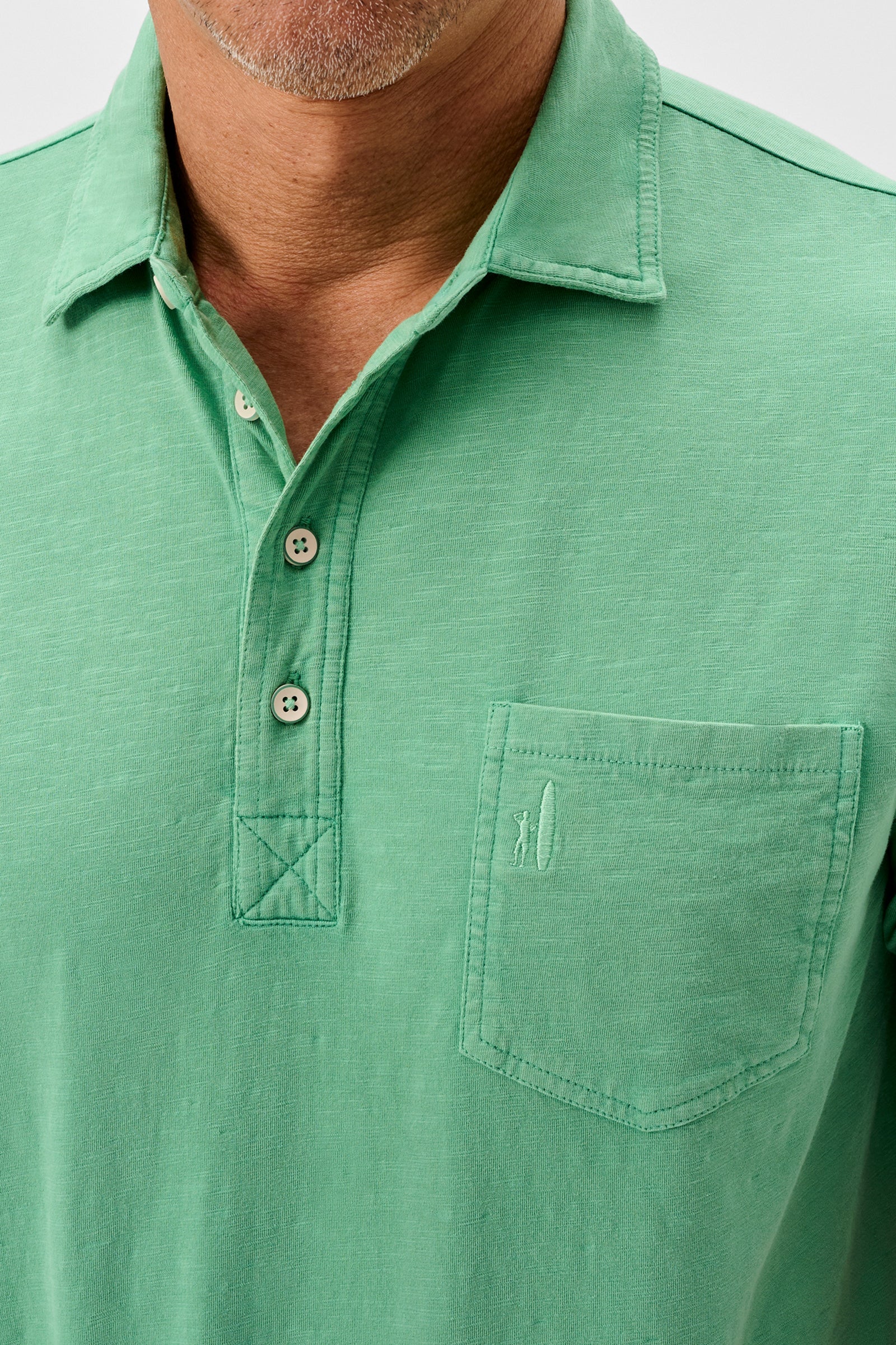 Green polo shirt with a pocket on a white background