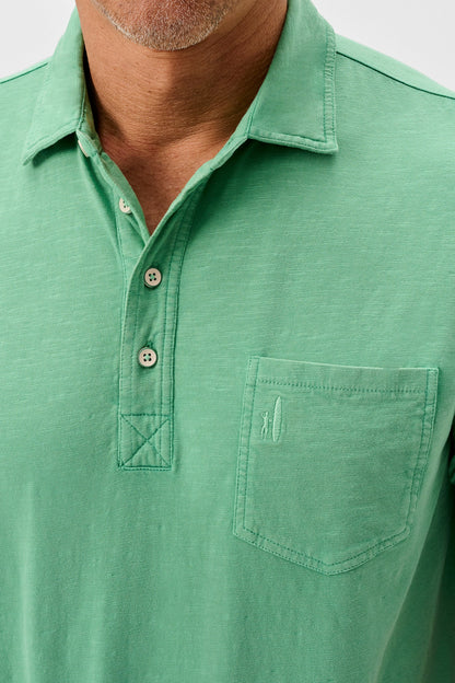 Green polo shirt with a pocket on a white background