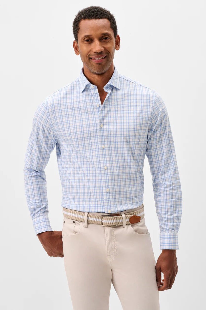 Man wearing a blue checkered shirt and beige pants on a white background