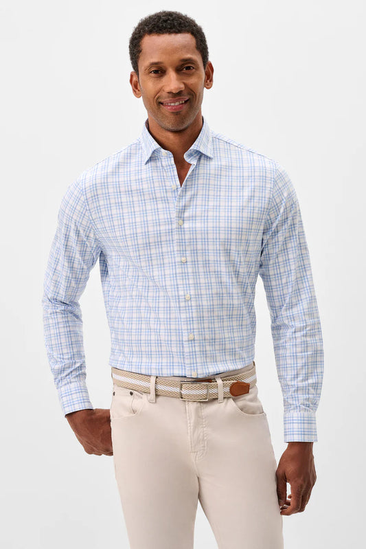 Man wearing a blue checkered shirt and beige pants on a white background