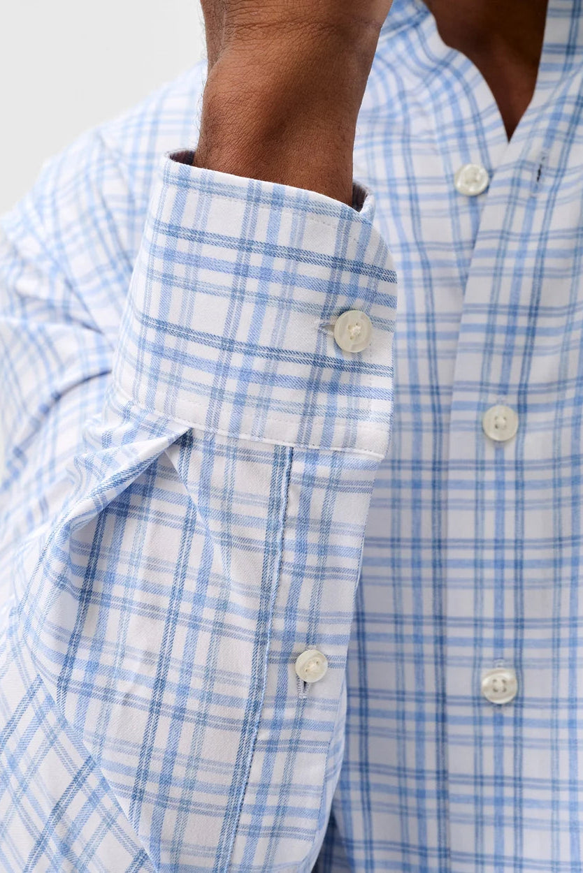 Close-up of a blue and white checkered shirt with buttons.