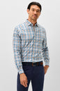 A man wearing a long-sleeve button-down shirt with a blue, white, and brown plaid pattern, paired with navy blue trousers and a brown belt, standing against a light gray studio background.
