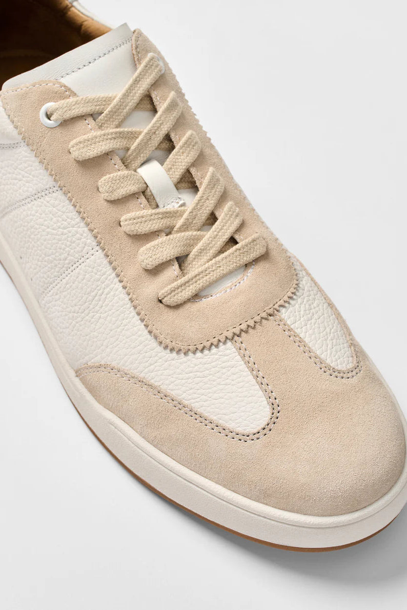 Beige sneaker with white laces on a light gray background